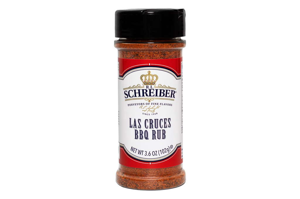 A bottle of RL Schreiber's Las Cruces BBQ Rub seasoning, featuring a black cap and a red and white label with gold detailing, set against a plain white background.